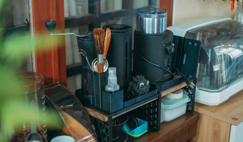 A tidy modern kitchen counter displaying various coffee-making equipment and kitchenware