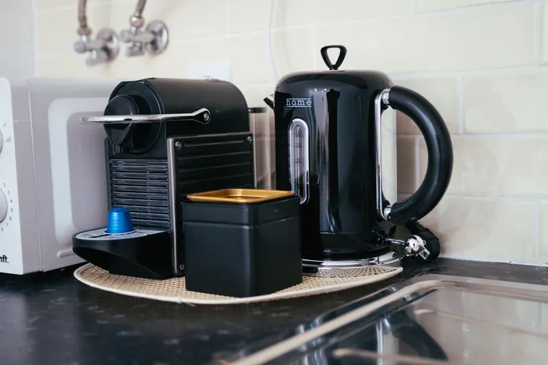 Sleek black coffee maker and kettle on a modern kitchen countertop, ideal for brewing